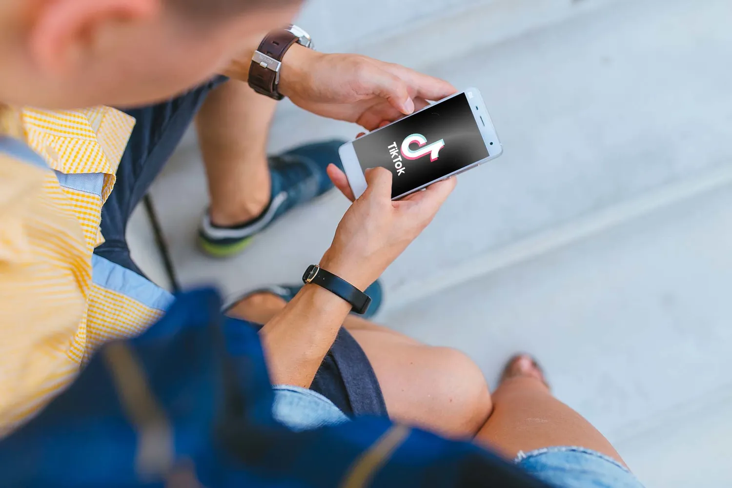 "Man using TikTok on iPhone" by Nordskov Media is marked with CC0 1.0.